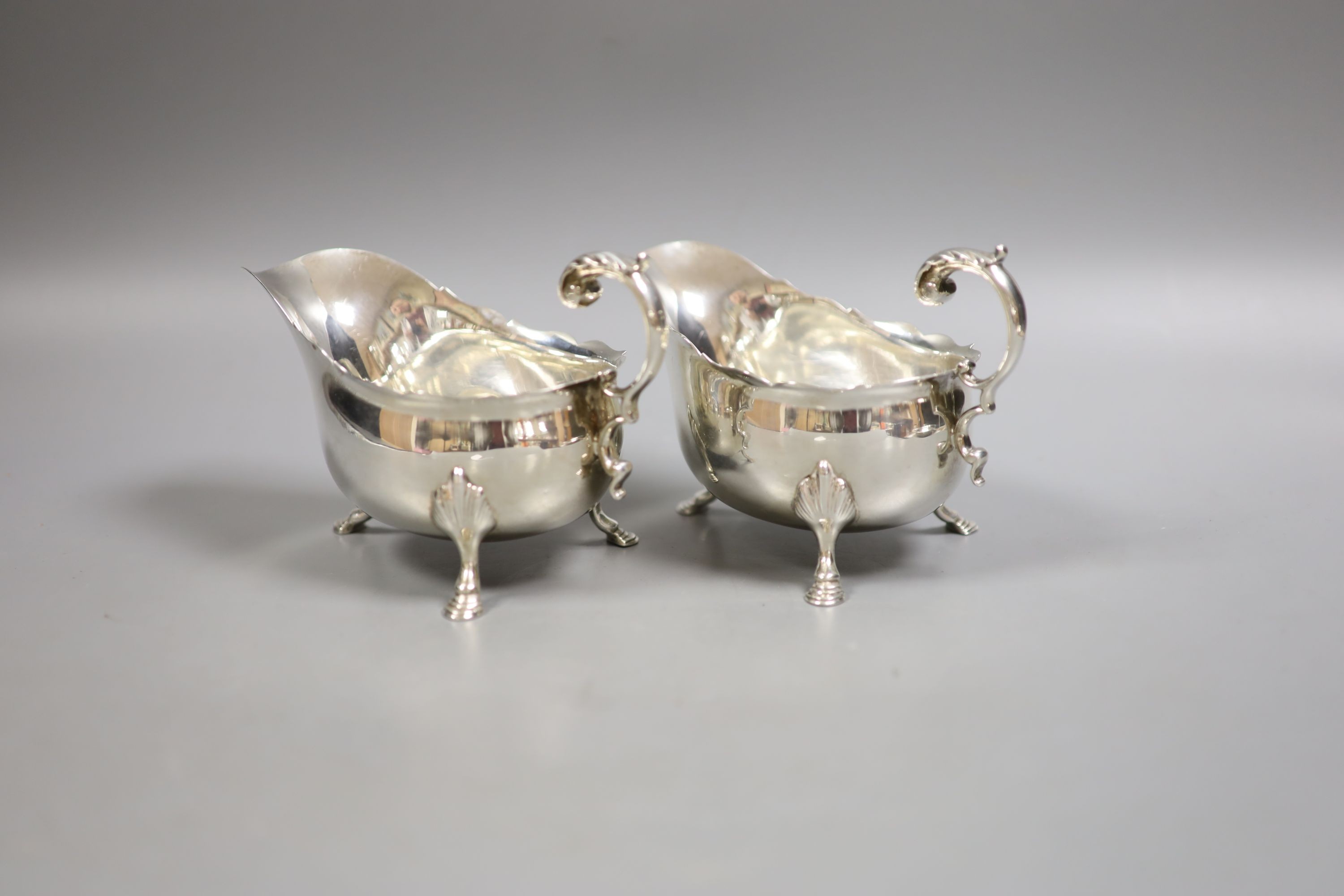 A pair of Edwardian silver sauceboats, with flying scroll handles, Henry Stratford Ltd, Sheffield, 1905/7, height 10.5cm, 17oz.